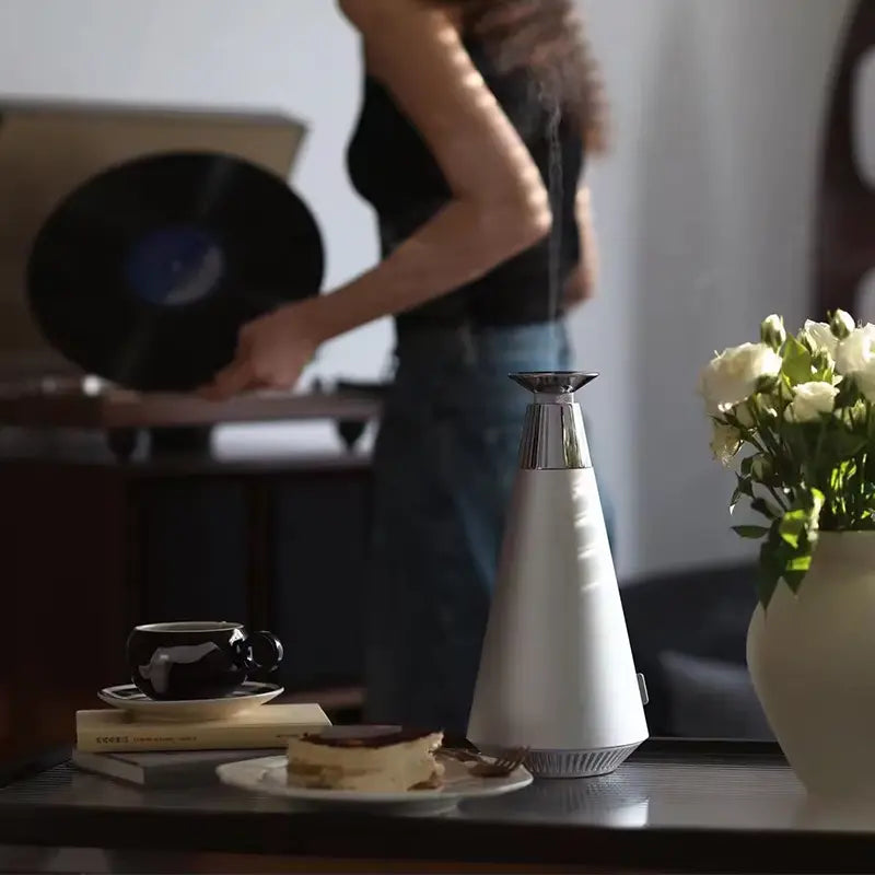 White humidifier on a table with a person in the background