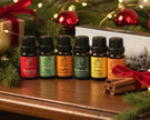 Set of essential oil bottles with Christmas decorations on a wooden surface