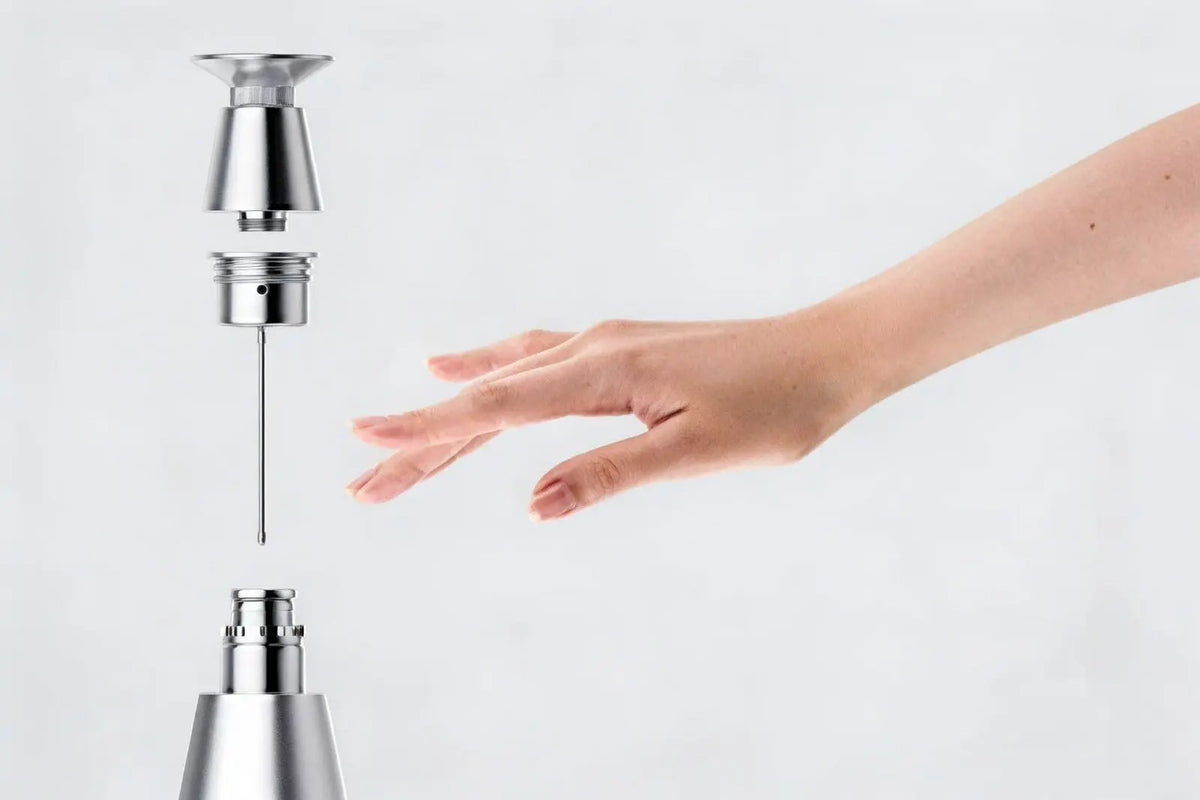 Hand reaching towards a touchless faucet on a white background