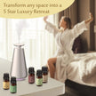 Woman in a bathrobe stretching in a bedroom with diffuser oil bottles and a diffuser.