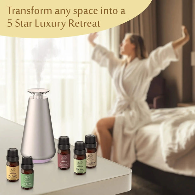 Woman in a bathrobe stretching in a bedroom with diffuser oil bottles and a diffuser.