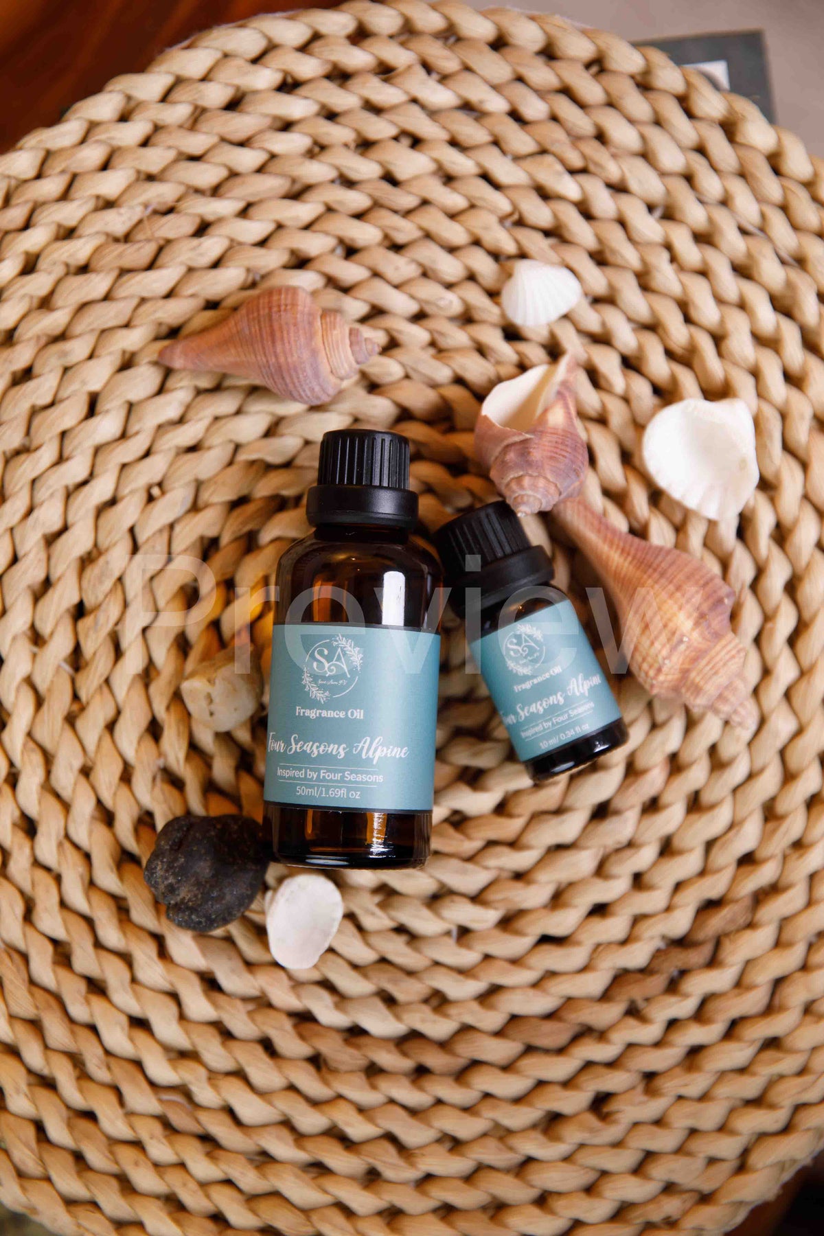 Two bottles of shampoo and conditioner with seashells on a woven mat