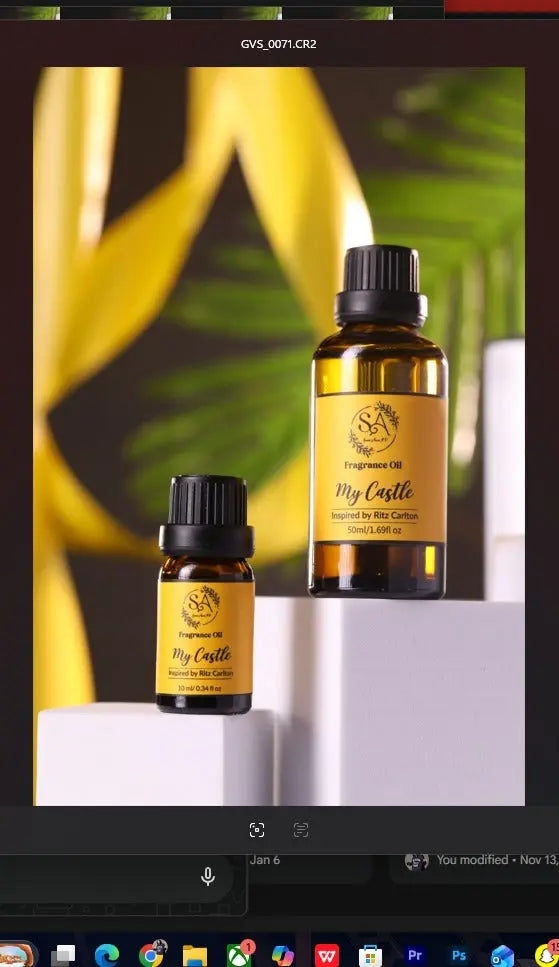 Two bottles of 'My Castle' fragranced oil on a white surface with green leaves in the background.