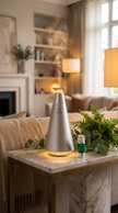 IV Luxe smart waterless diffuser on a marble console in a modern living room with mist rising